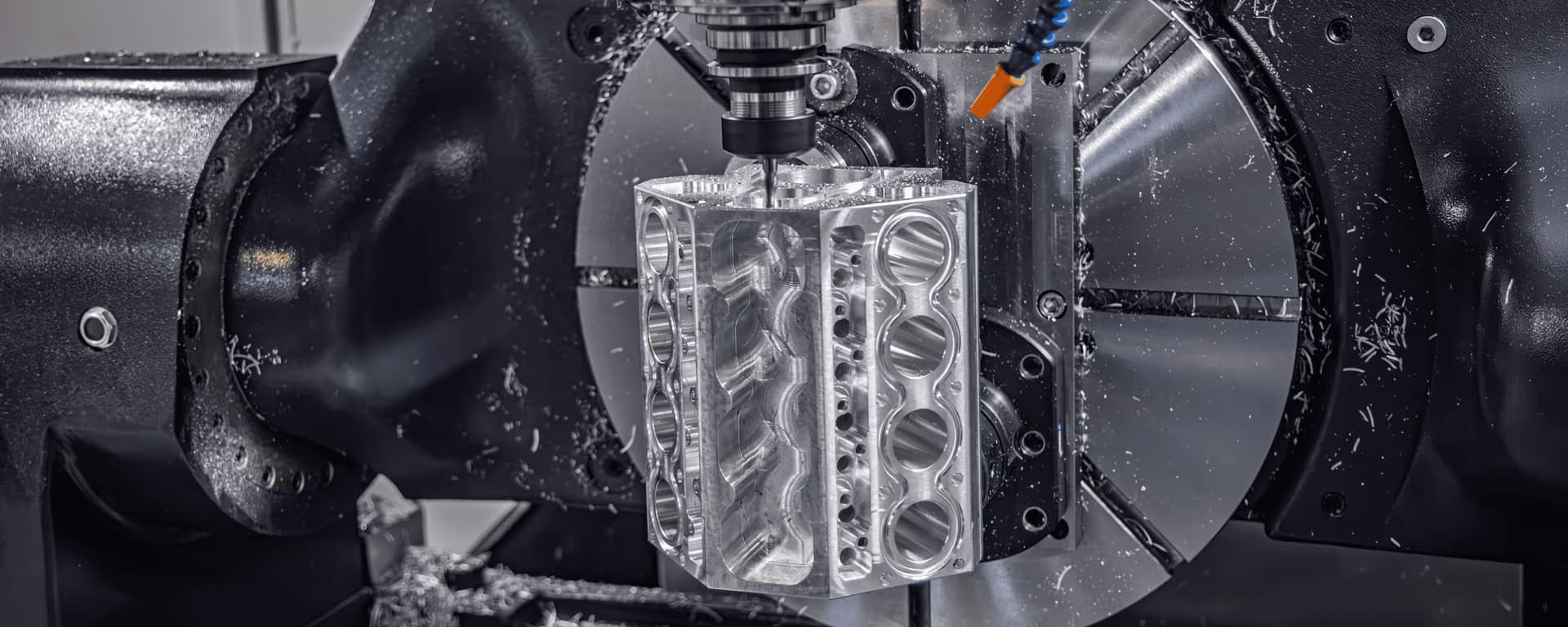 CNC machine cutting a metal block with multiple holes